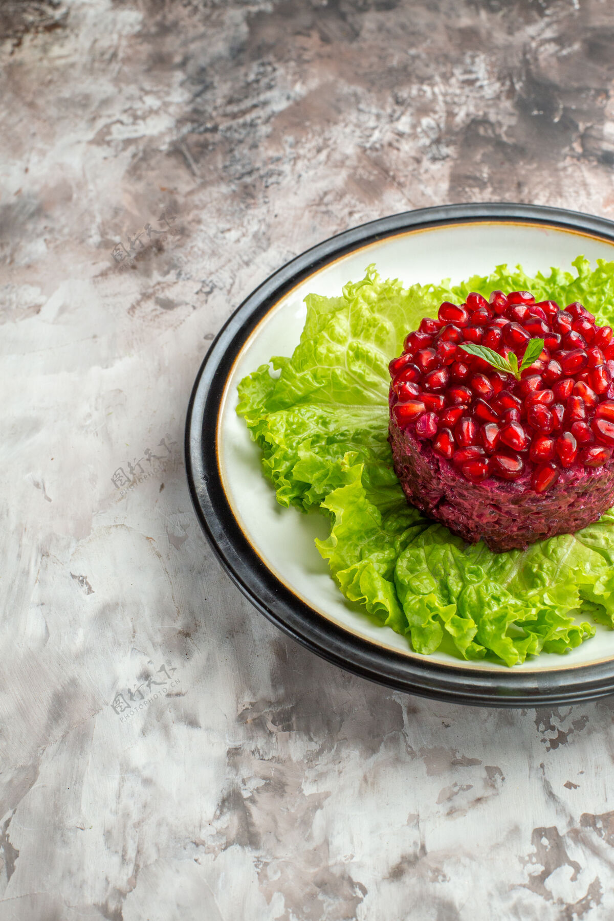 膳食正面是美味的石榴沙拉 圆形的绿色沙拉 背景是清淡的饮食保健餐健康正面浆果