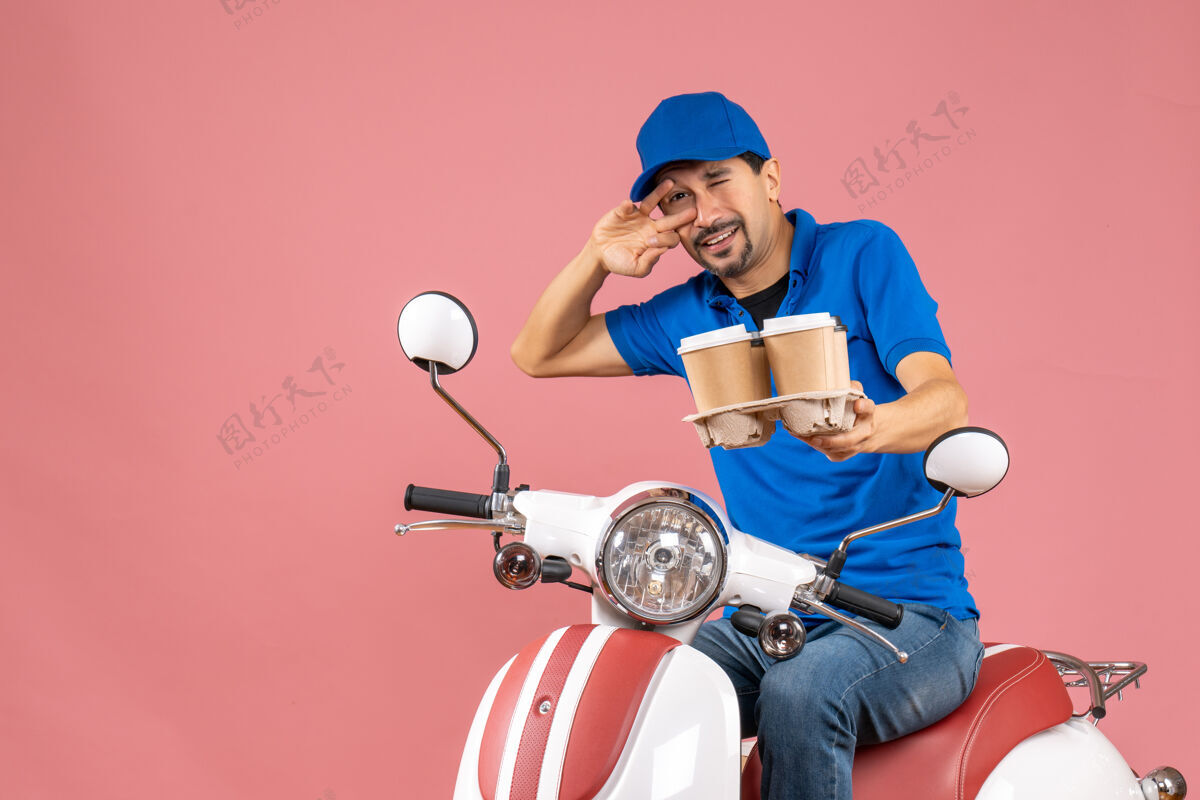 粉彩前视图疯狂的情感有趣的信使男子戴帽子坐在粉彩桃色背景踏板车成人快递员情感