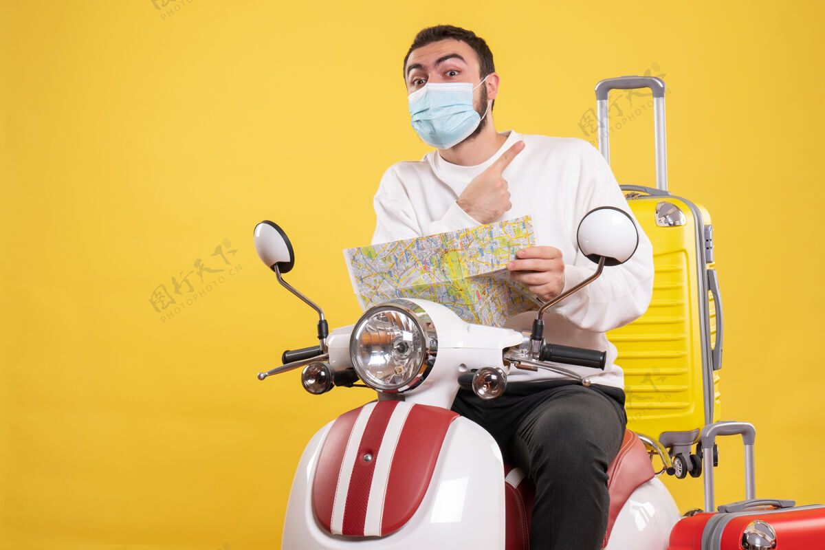 男旅行的概念与惊讶的家伙在医疗面具坐在摩托车上黄色手提箱上人旅行摩托车