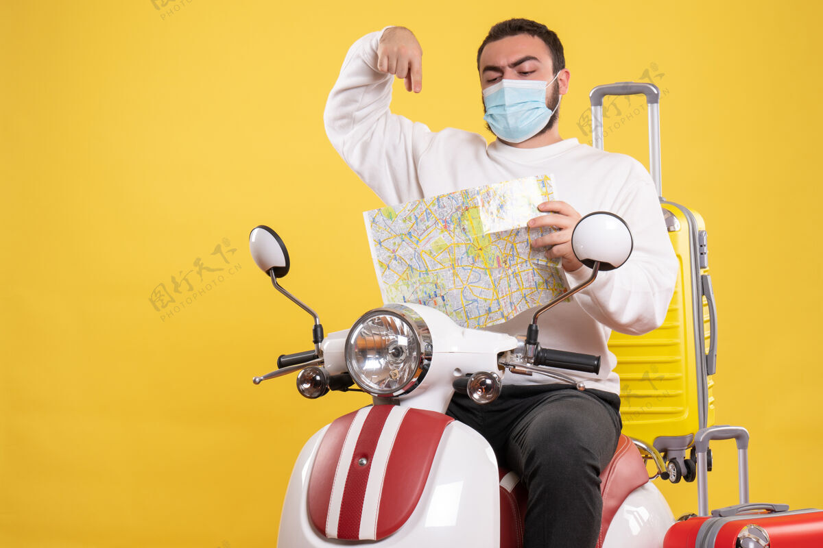 高尔夫旅行的概念与自信的家伙在医疗面具坐在摩托车上 黄色的手提箱上车辆坐着旅行