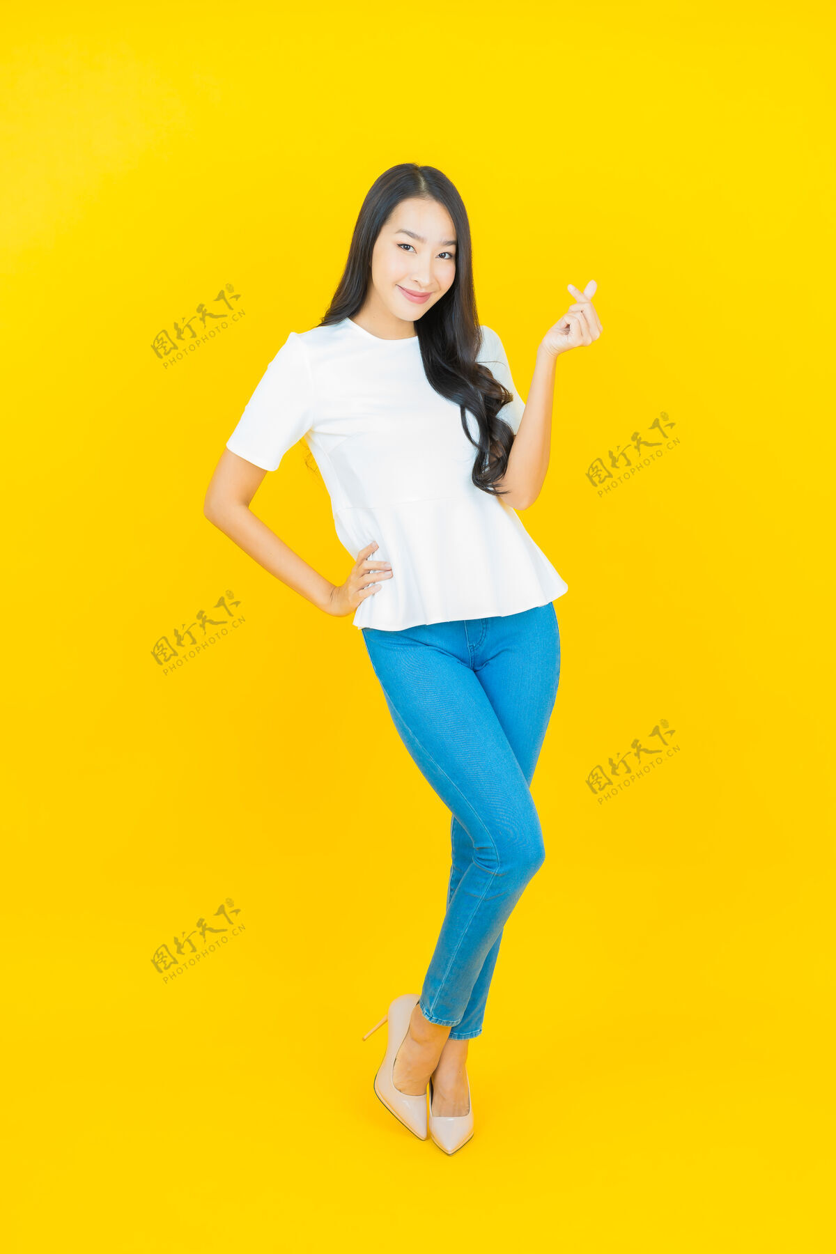 人美丽的亚洲年轻女子在黄色的脸上微笑卷发Swoosh成人