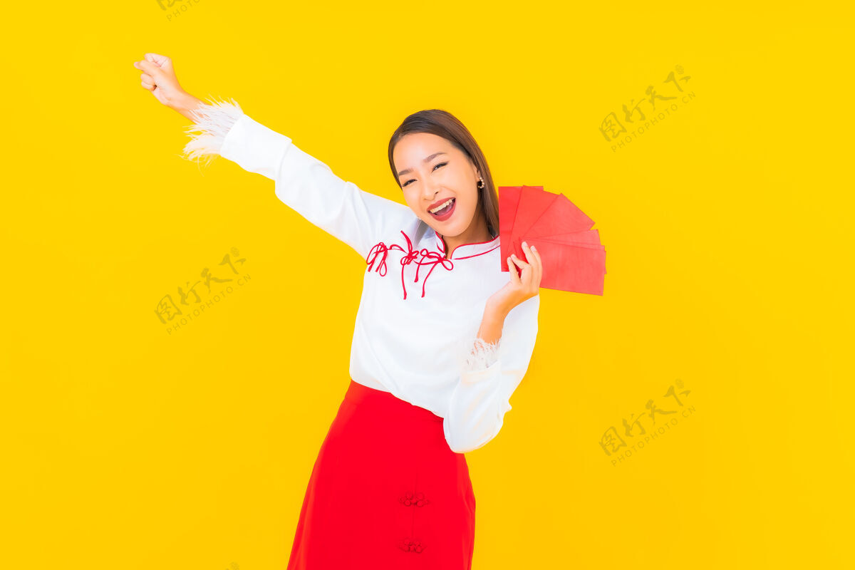 漂亮肖像美丽的亚洲年轻女子与红包信在中国新年的黄色亚洲东方人类