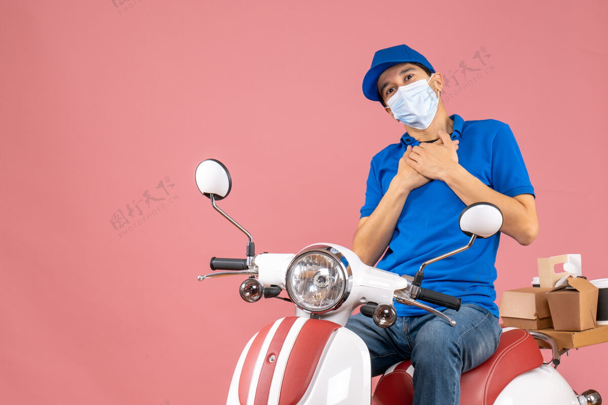 人俯视图：戴着医用面罩 戴着帽子 坐在粉彩桃色滑板车上的感谢快递员面罩摩托车坐