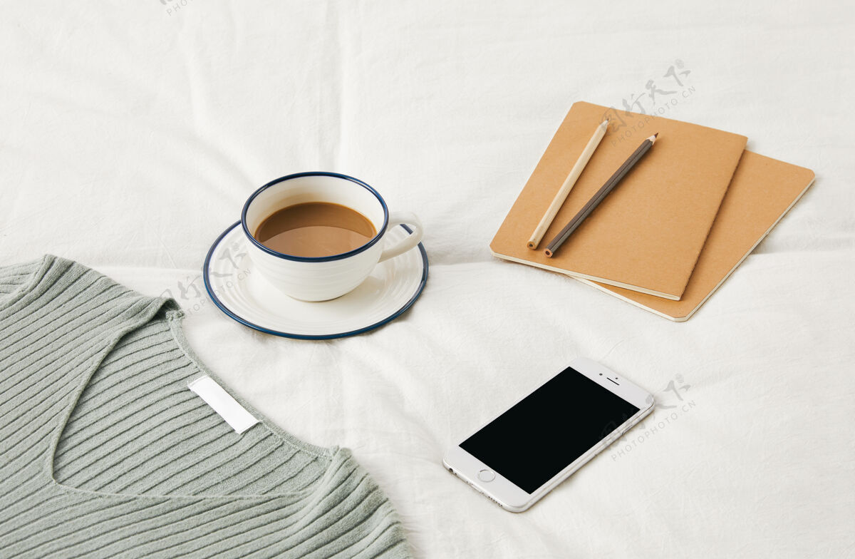 日记一杯咖啡放在床单上的高角度照片 上面有素描本 电话和毛衣床单角度电话