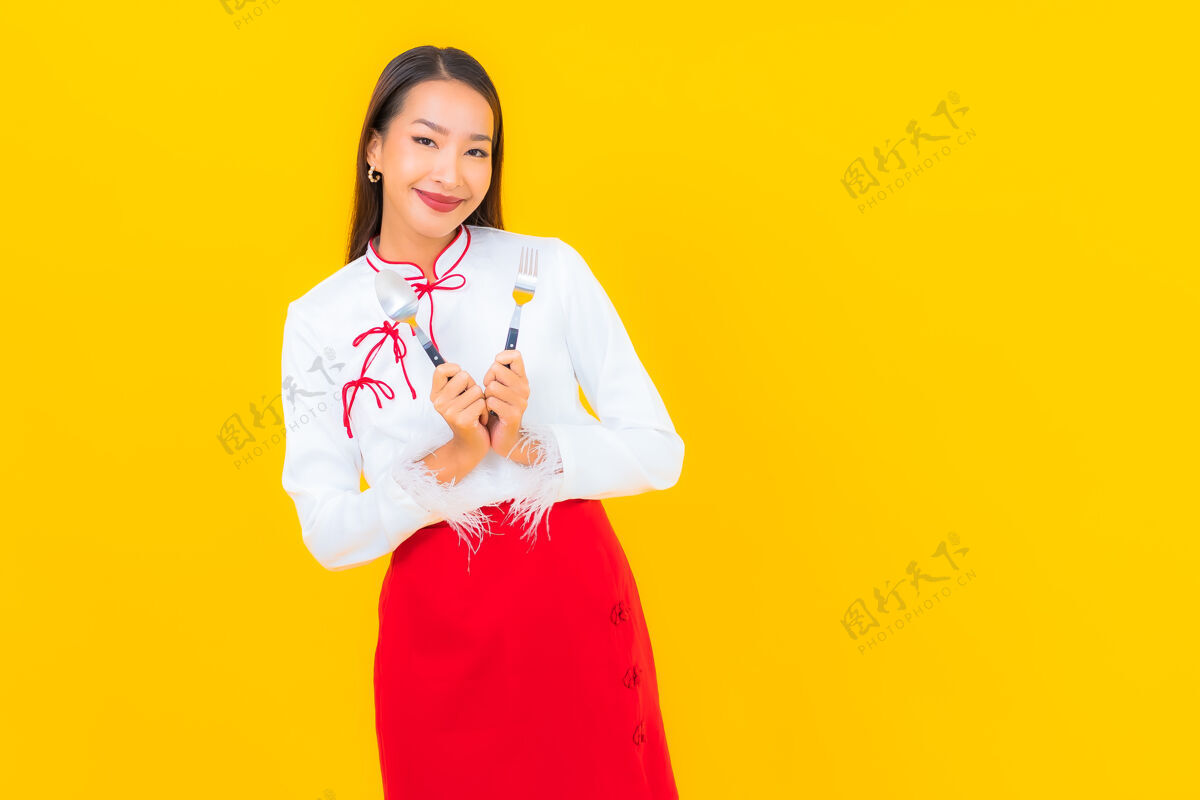 用餐画一个年轻漂亮的亚洲女人 用黄色的勺子和叉子休闲单身减肥