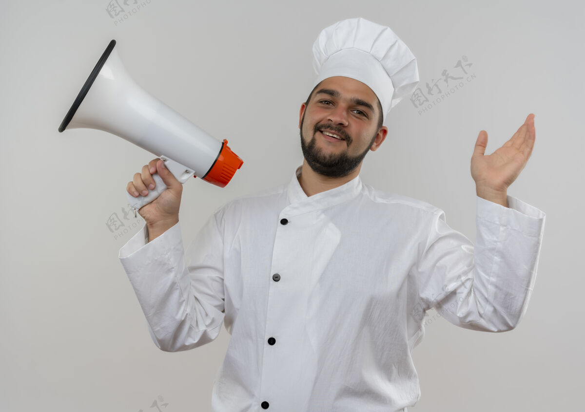 抱着快乐的年轻男厨师身着厨师制服 手持扬声器 举手孤立地站在白墙上厨师男性提高