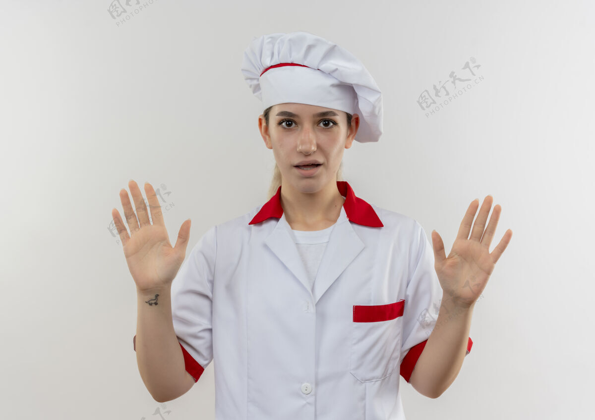 显示令人印象深刻的年轻漂亮厨师在厨师制服显示空手孤立在白墙上空漂亮手
