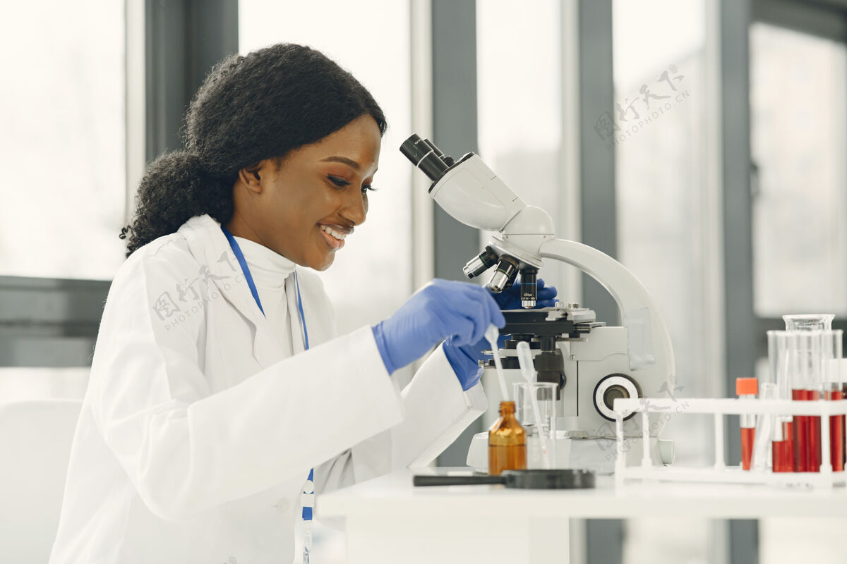 职业医学博士 一个拿着显微镜工作的女孩年轻的女科学家在做疫苗研究微生物学工作医学
