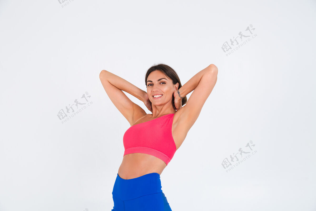 运动适合皮肤黝黑的运动型女性 拥有腹肌 健康曲线 穿着上衣和白色蓝色紧身裤仰卧起坐腹肌身体