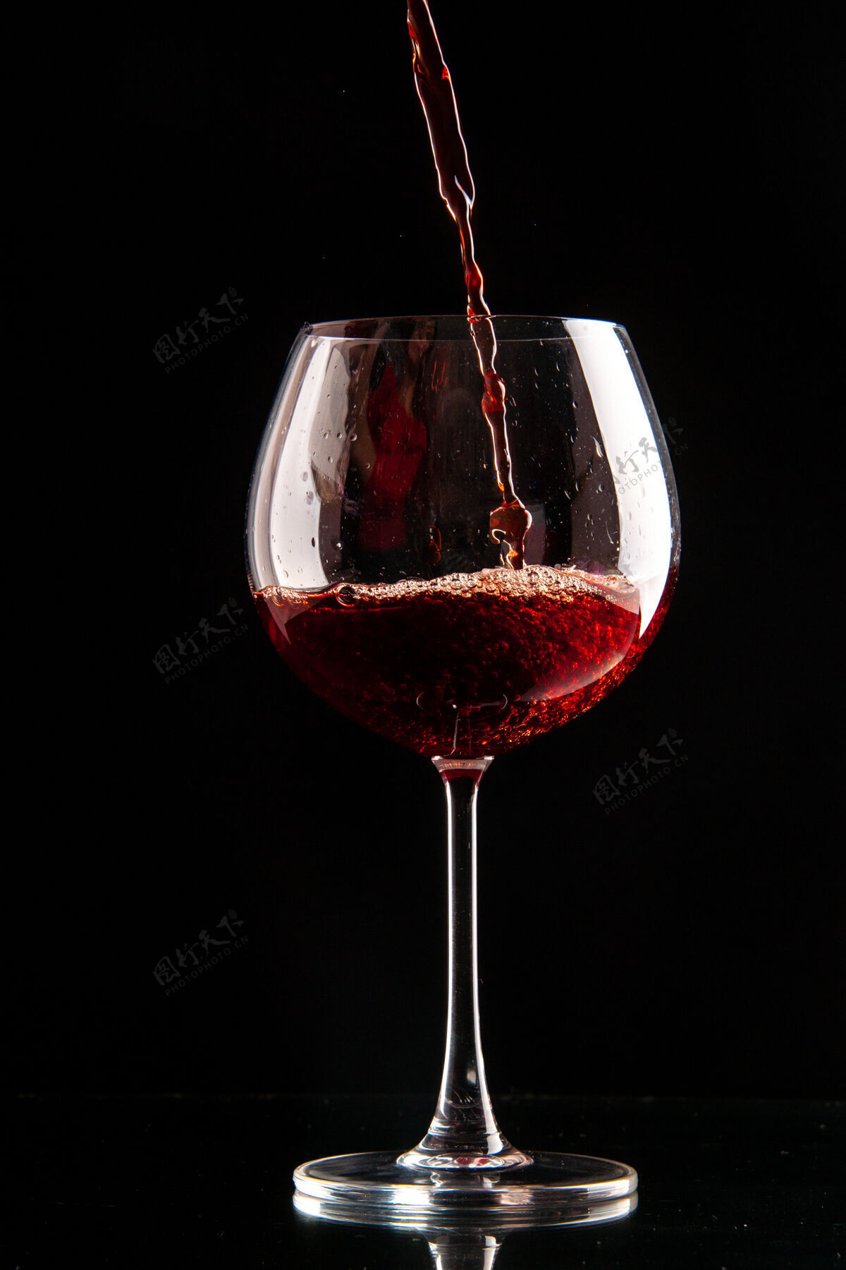 酒杯前视酒杯 在黑色的酒杯上倒入红酒 喝香槟庆祝圣诞成人酒杯葡萄酒