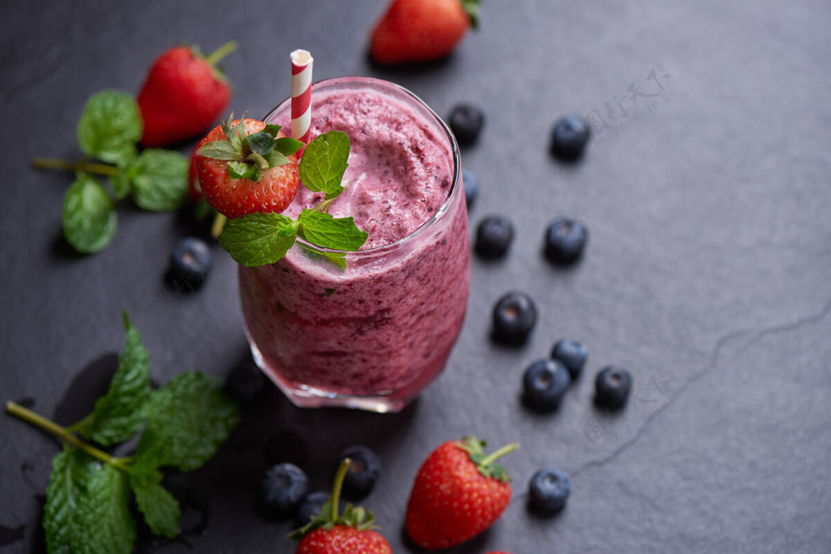 早餐美味的草莓 桑葚和蓝莓冰沙点缀着新鲜的浆果和薄荷柔和的焦点美丽的开胃品粉色覆盆子 健康和减肥的概念水果自制草莓