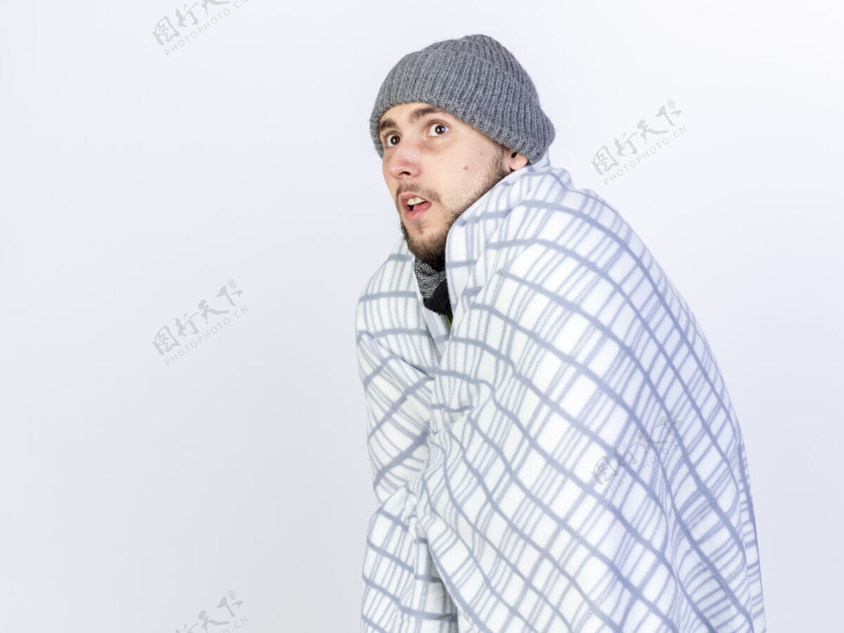 包裹焦虑的年轻白种人 戴着冬天的帽子 站在一边 裹着格子呢焦虑男人站立