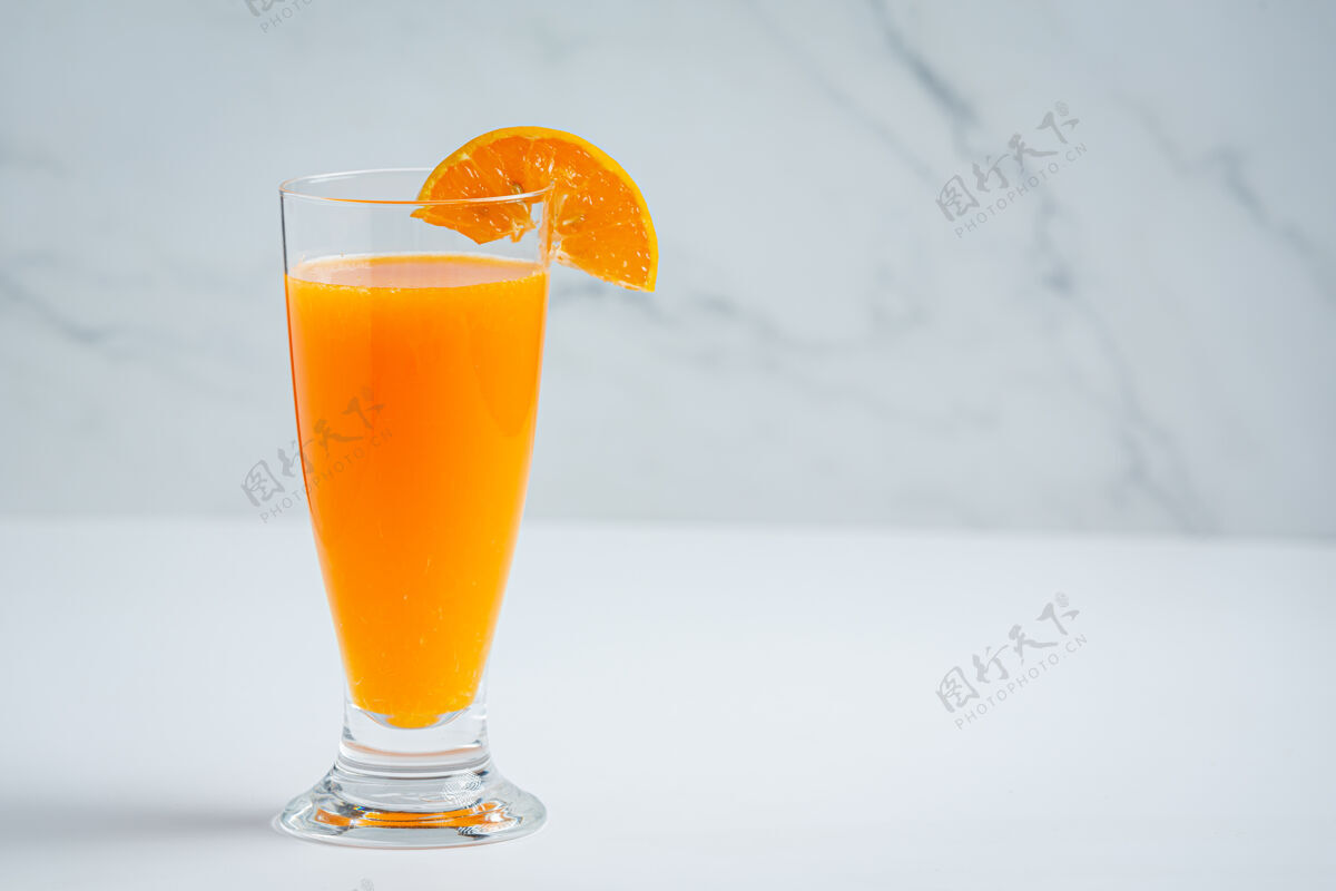 木头新鲜的橙汁在玻璃大理石背景上玻璃杯切割美味