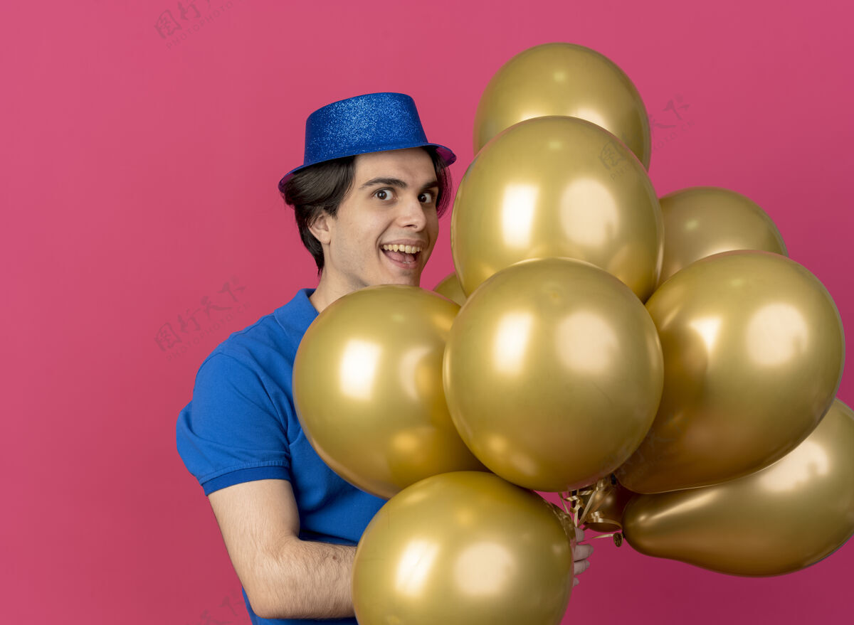 男人高加索帅哥戴着蓝色派对帽手持氦气球兴奋派对氦