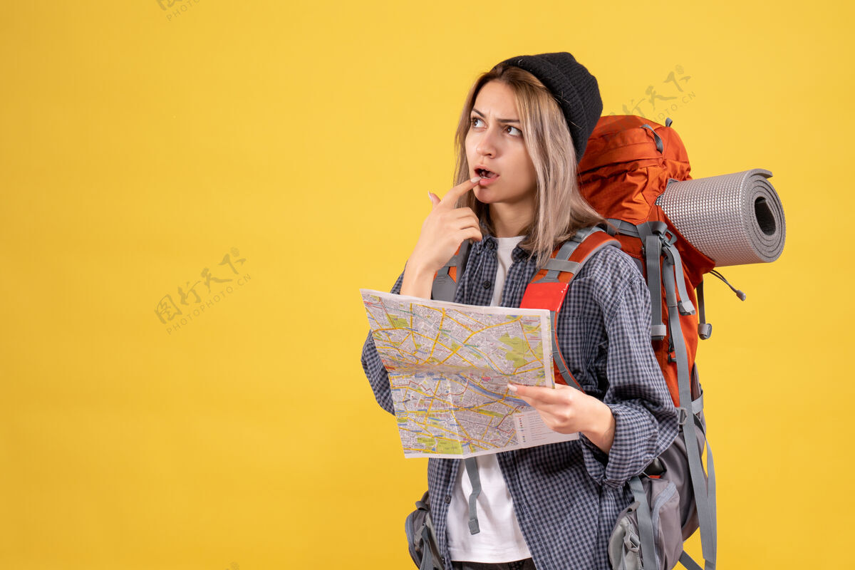 人体贴的女旅行者背着背包拿着地图背包长袍肖像