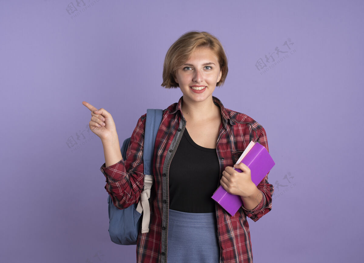 壁板微笑着的年轻斯拉夫学生女孩背着书包 手里拿着书和笔记本微笑笔记本持有