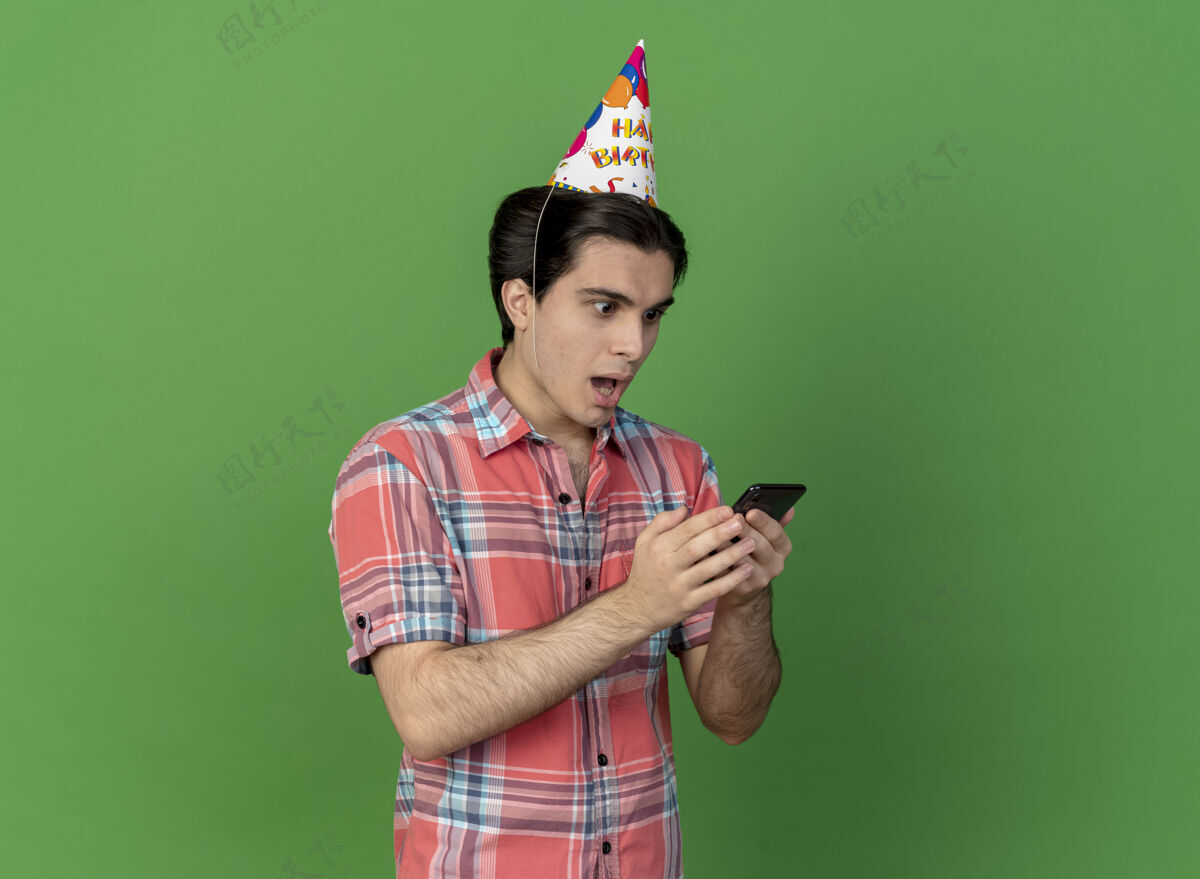 帽子一个戴着生日帽的白人帅哥拿着手机看着电话穿男人帅哥