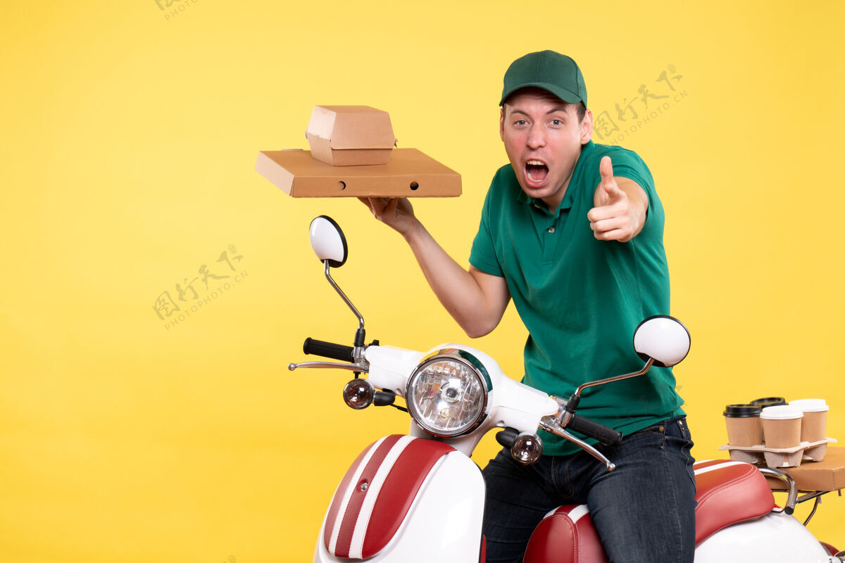 工作正面图身着制服的年轻男性快递员手持黄色食品包装制服摩托车成人
