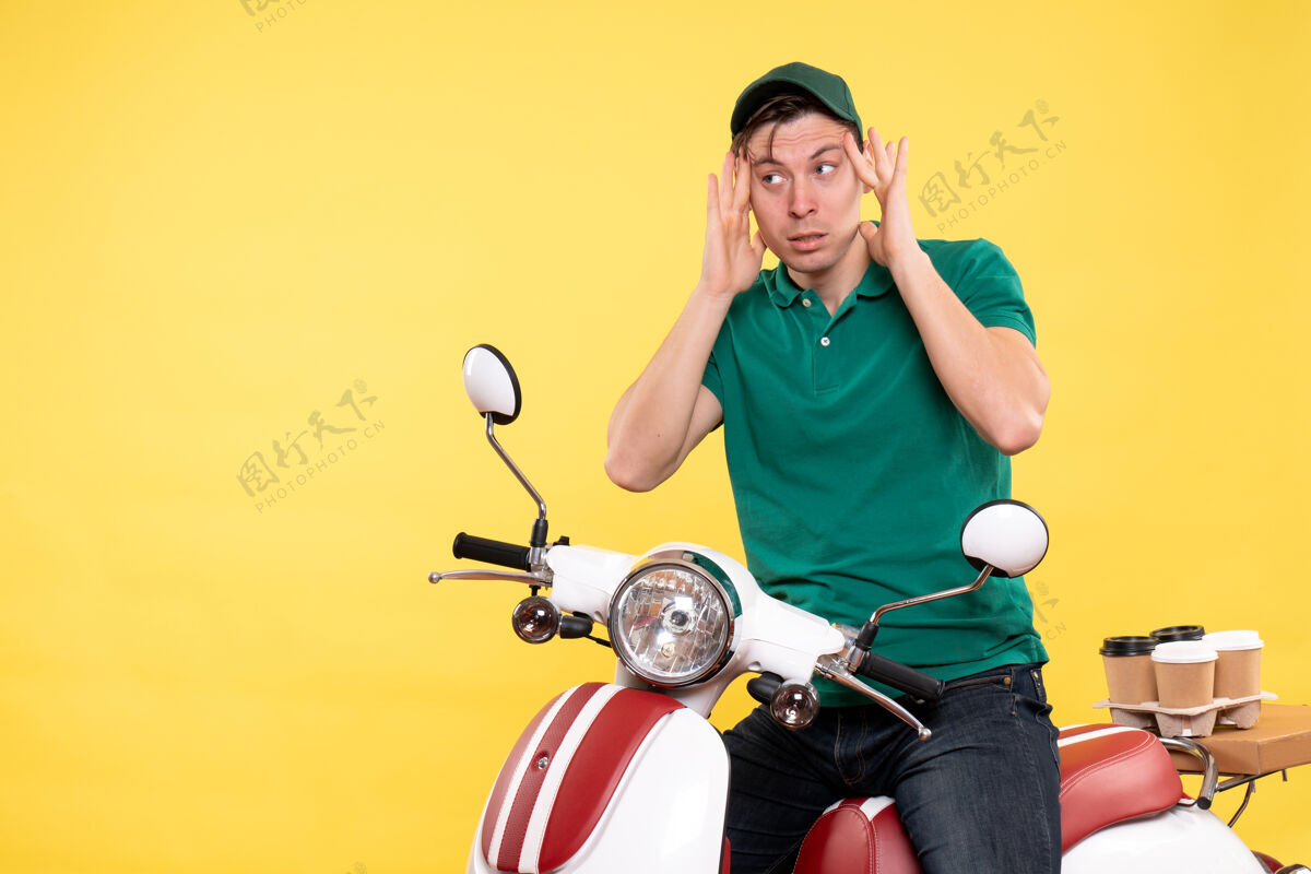 送货正面图：穿着绿色制服骑着黄色自行车的年轻男信使活动摩托车服务