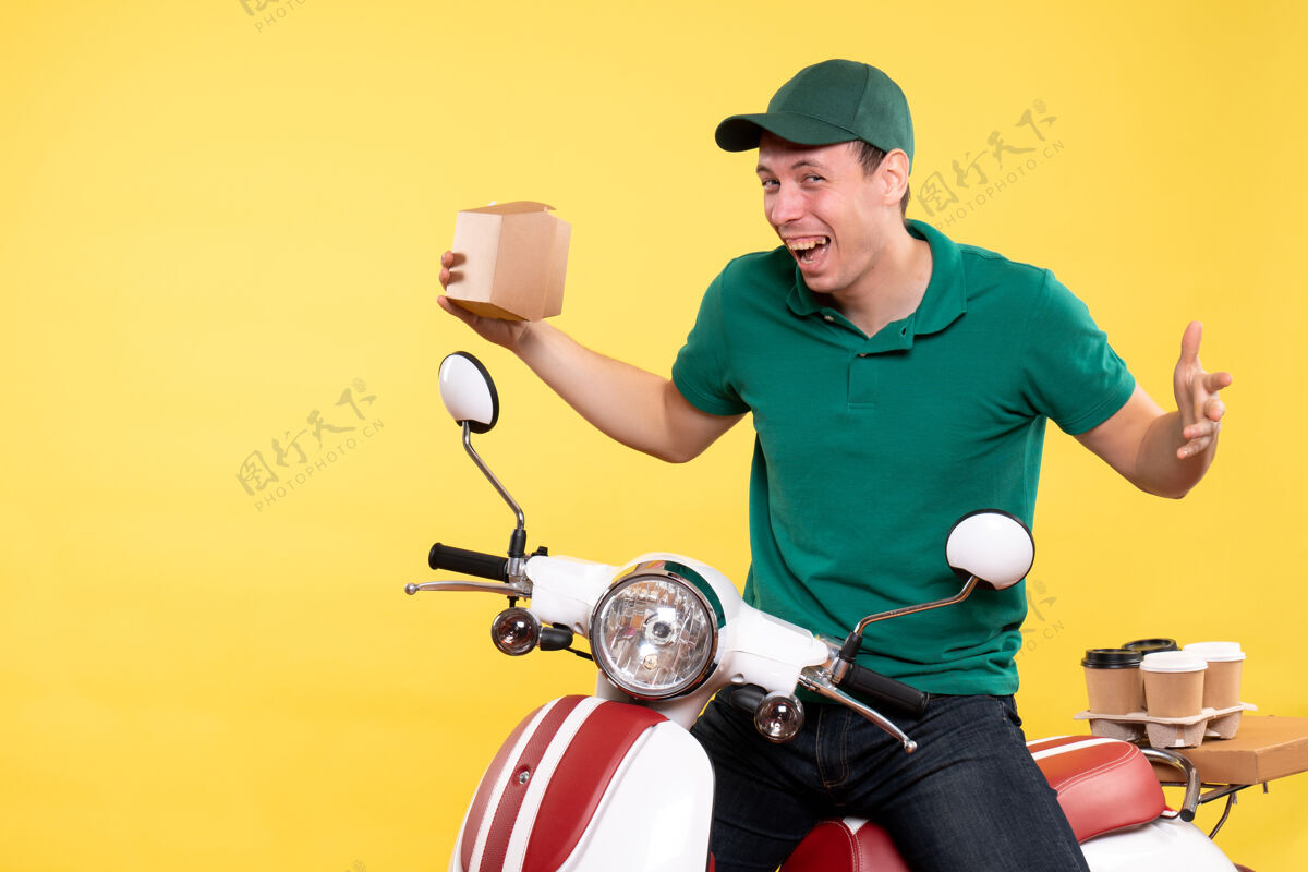 男快递员正面图穿着制服的男信使拿着黄色的小食品包工作工作包装