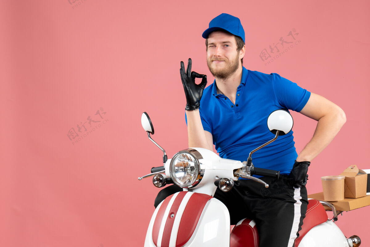 自行车正面图：身穿蓝色制服的男性信使站在粉红色的一边人服务男信使