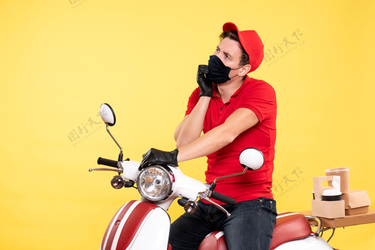 成人正面图：穿着红色制服 戴着黄色面具的男信使工作车辆服务