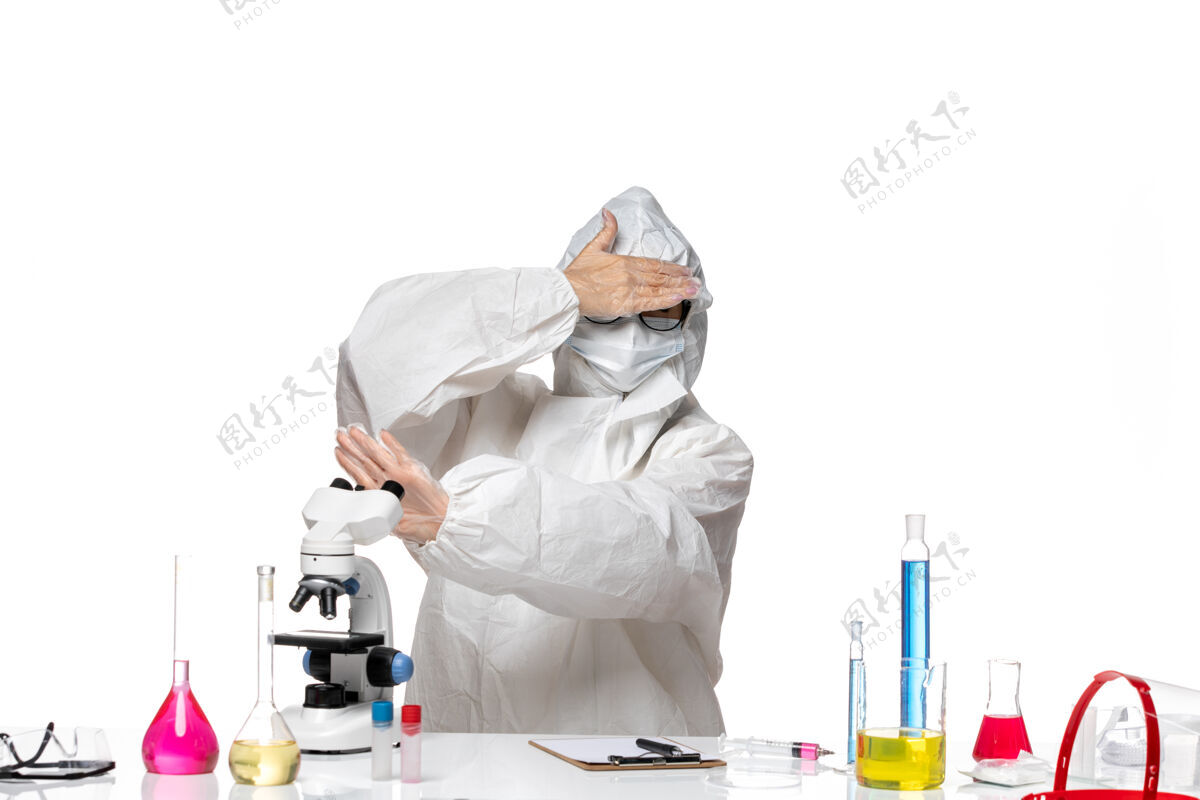 防护正面图年轻的女化学家穿着特殊的防护服不想在显微镜下看白色背景上的病毒实验室冠状病毒-化学人医生医疗