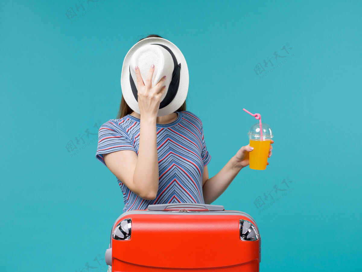 旅程前景度假女人拿着果汁在蓝色的背景上远航度假海上旅行旅程人果汁