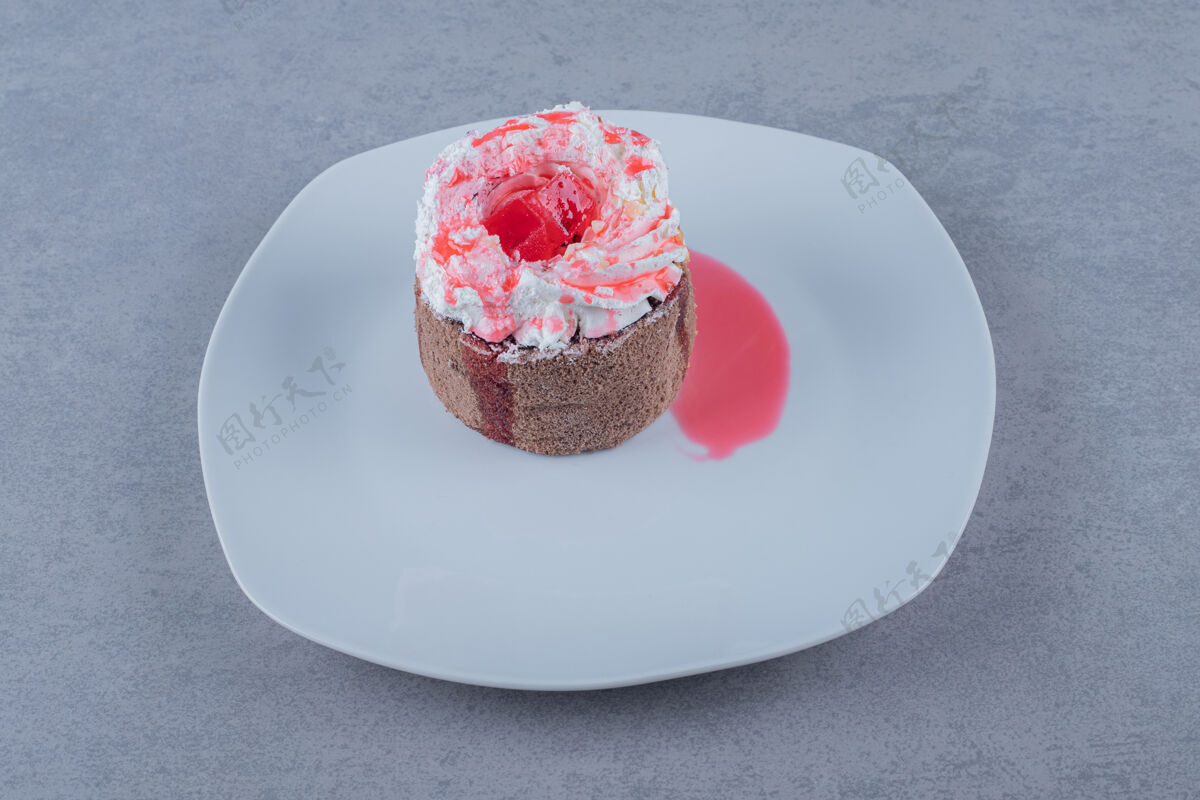 奶油自制迷你奶油蛋糕 白色盘子上有粉色酱汁糕点烹饪块
