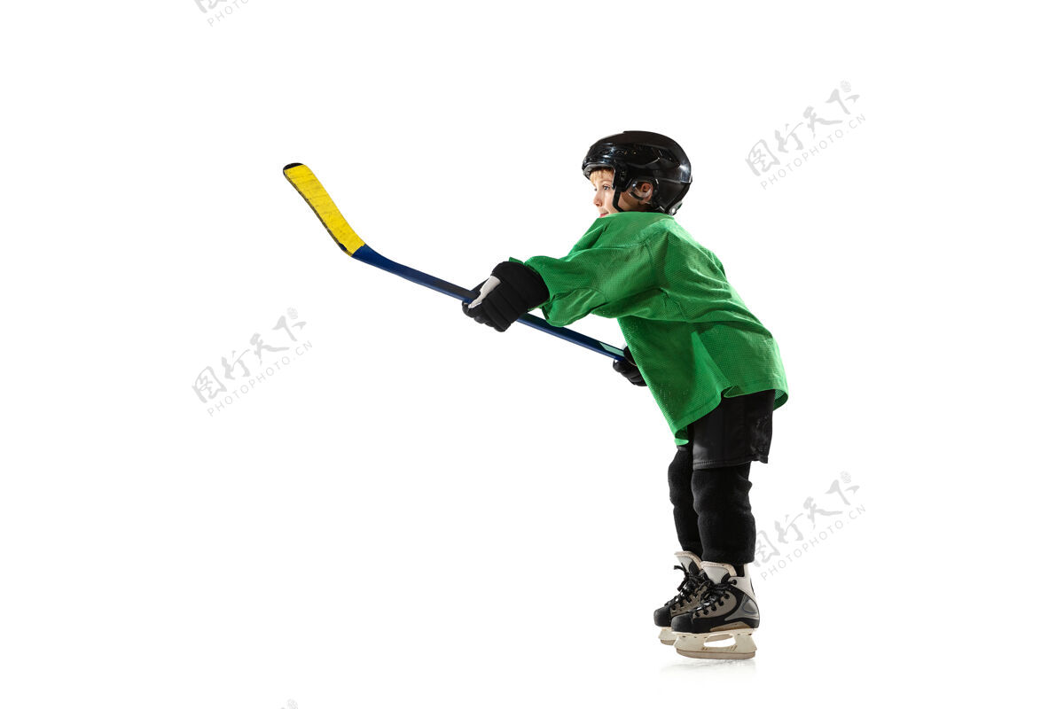 年轻冰球场上的小冰球手 白色的工作室墙动作棍棒头盔