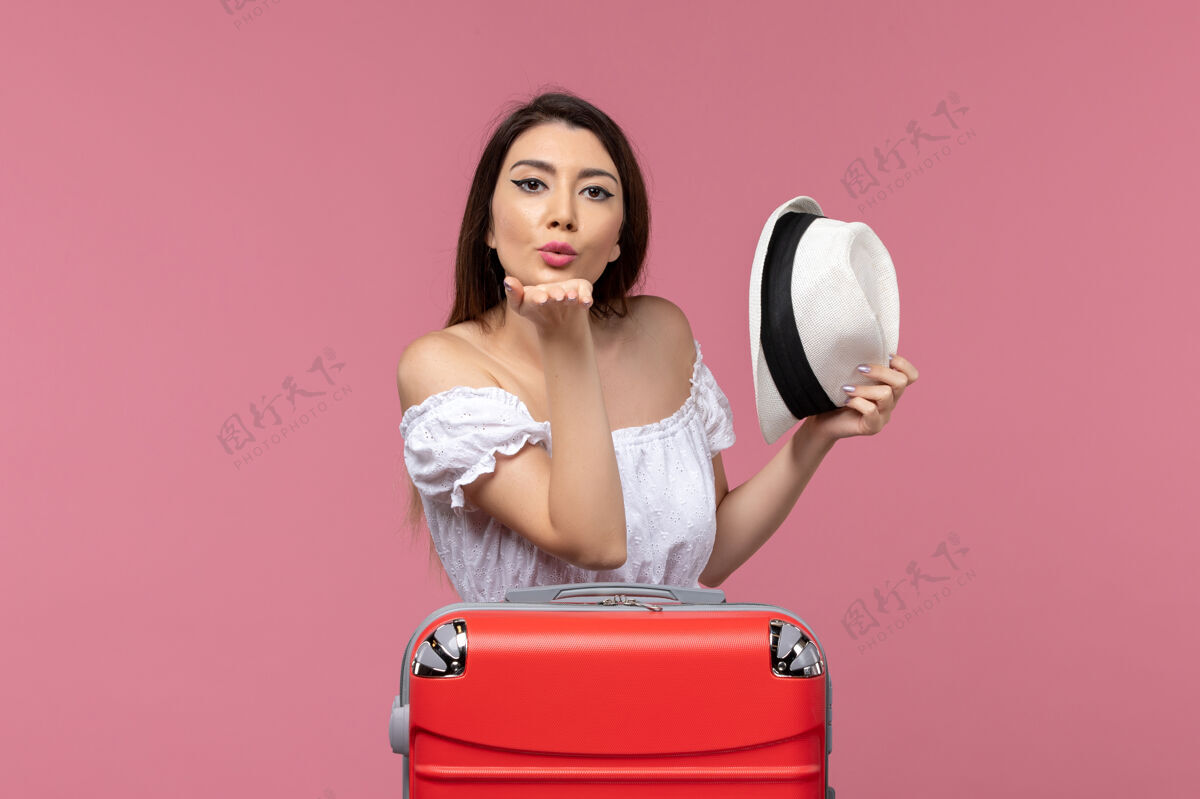 发送正面图年轻女性准备度假 送上粉红色背景的飞吻出国旅游海上旅行肖像航空年轻女性