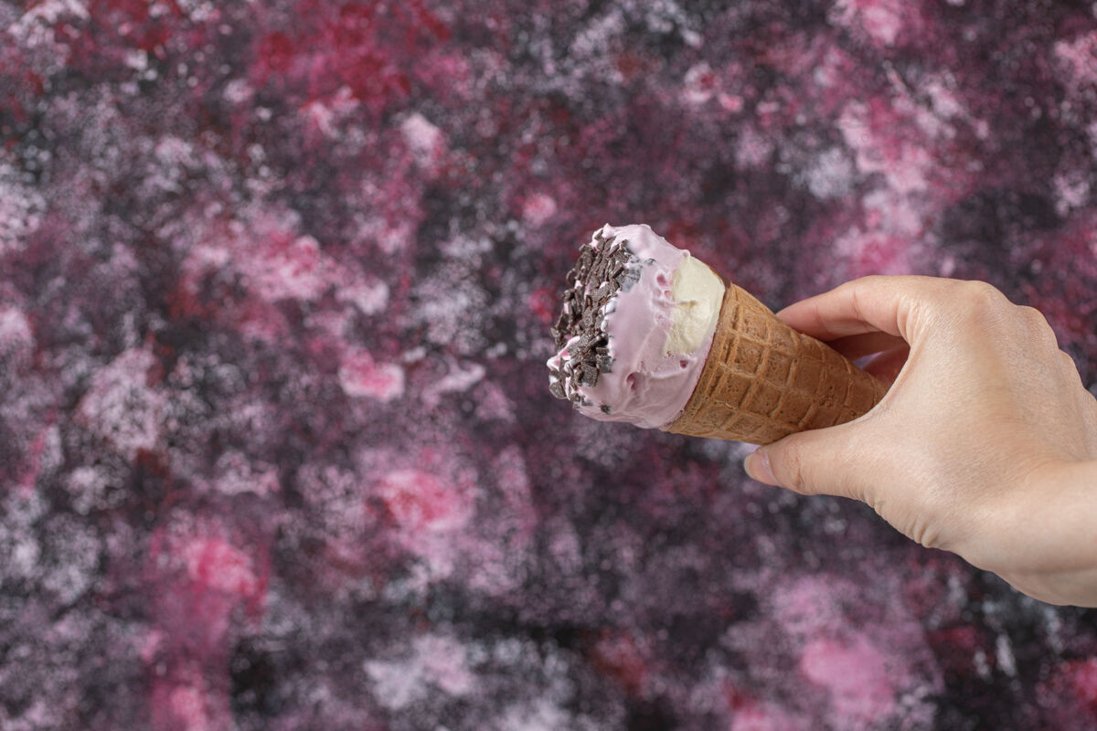 脆手里拿着一个华夫饼筒里的蓝莓冰淇淋喜悦美味巧克力