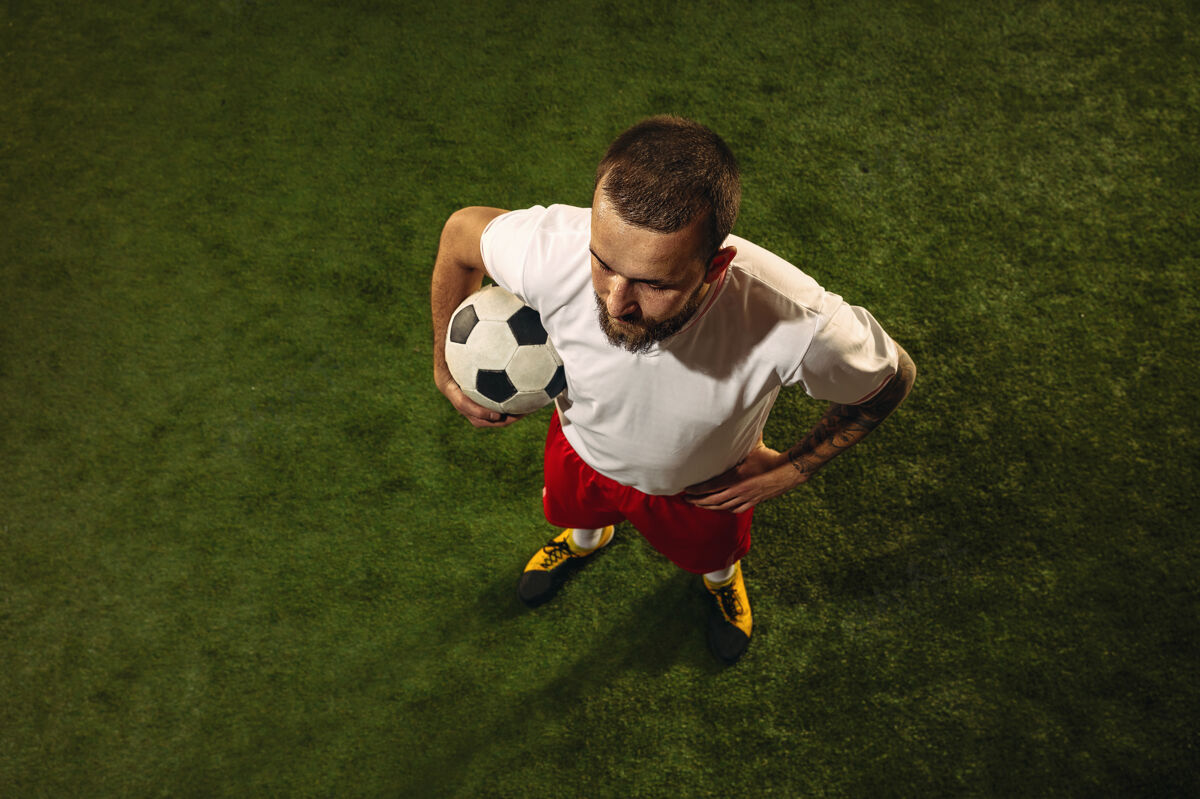 比赛绿草上足球或足球运动员的顶视图踢休闲运动