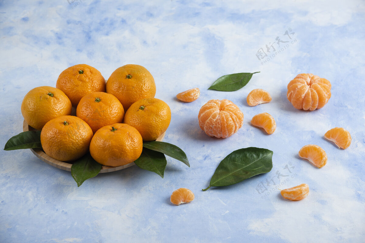 餐桌在木板上和地上堆着一堆桔子橘子美味饮食