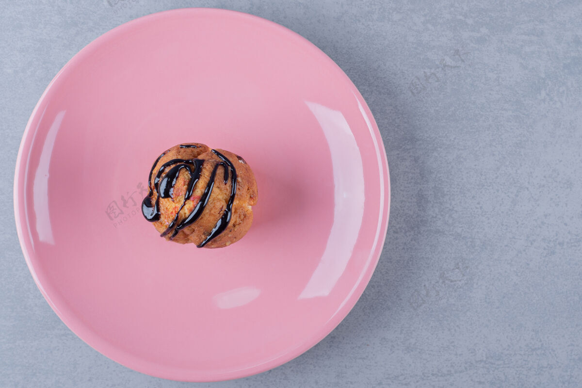折叠自制香蕉焦糖松饼放在粉红色盘子里饼干餐特写