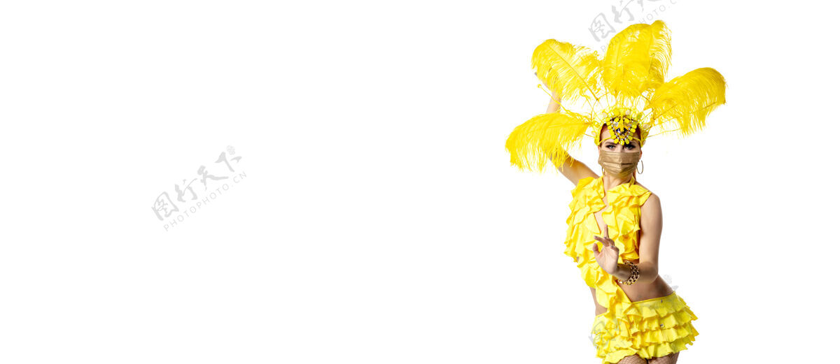 服装表演身着嘉年华化装 黄色羽毛的美丽年轻女子在白色背景上翩翩起舞节日庆典 节日时间 舞蹈 聚会 快乐的概念复制空间威尼斯集团华丽