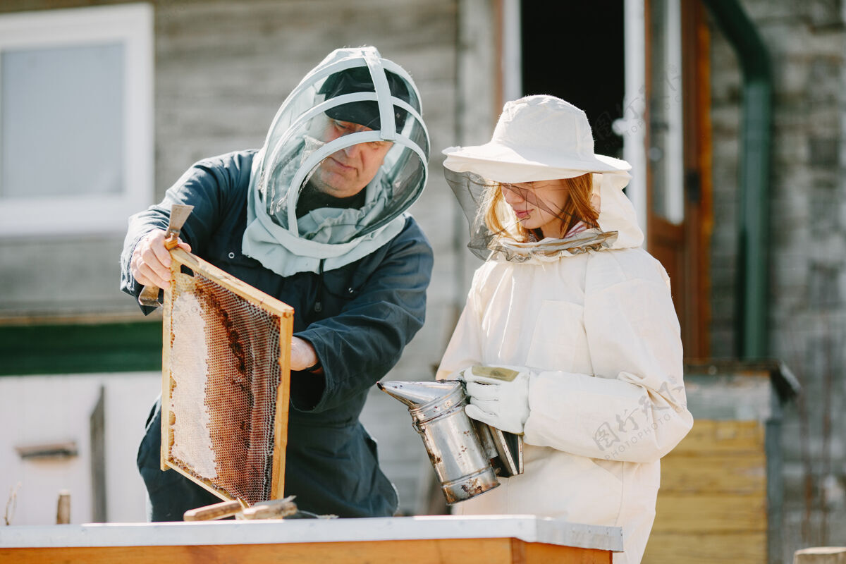 农场两个养蜂人在养蜂场工作穿着工作服工作人农业保持