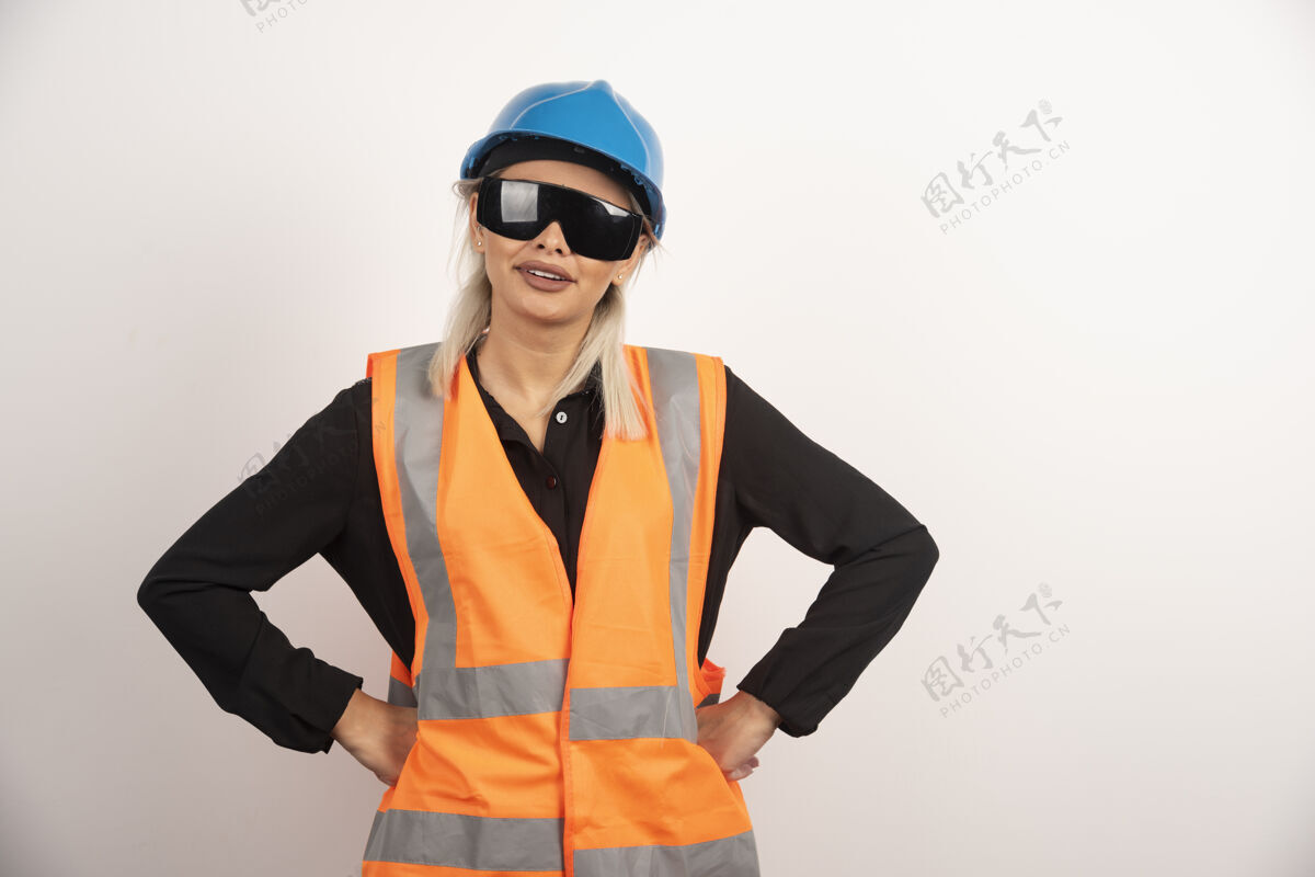 头盔微笑的女建筑工人与护目镜和头盔摆姿势高品质的照片建筑人类女性