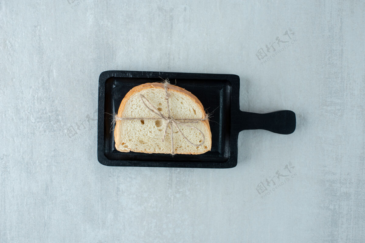 面包房白面包用绳子绑在黑木板上吐司白面包木材