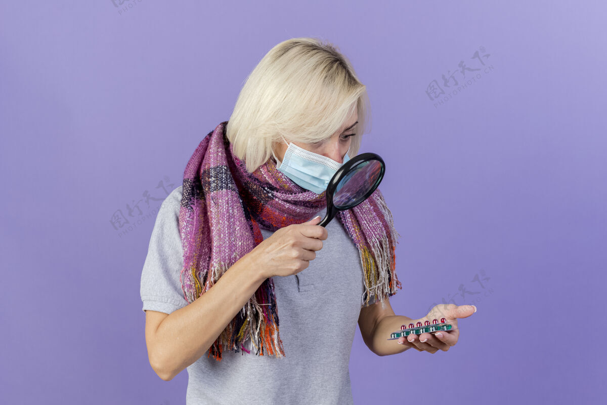 放大镜年轻的金发病斯拉夫妇女戴着医用面具和围巾疾病斯拉夫玻璃