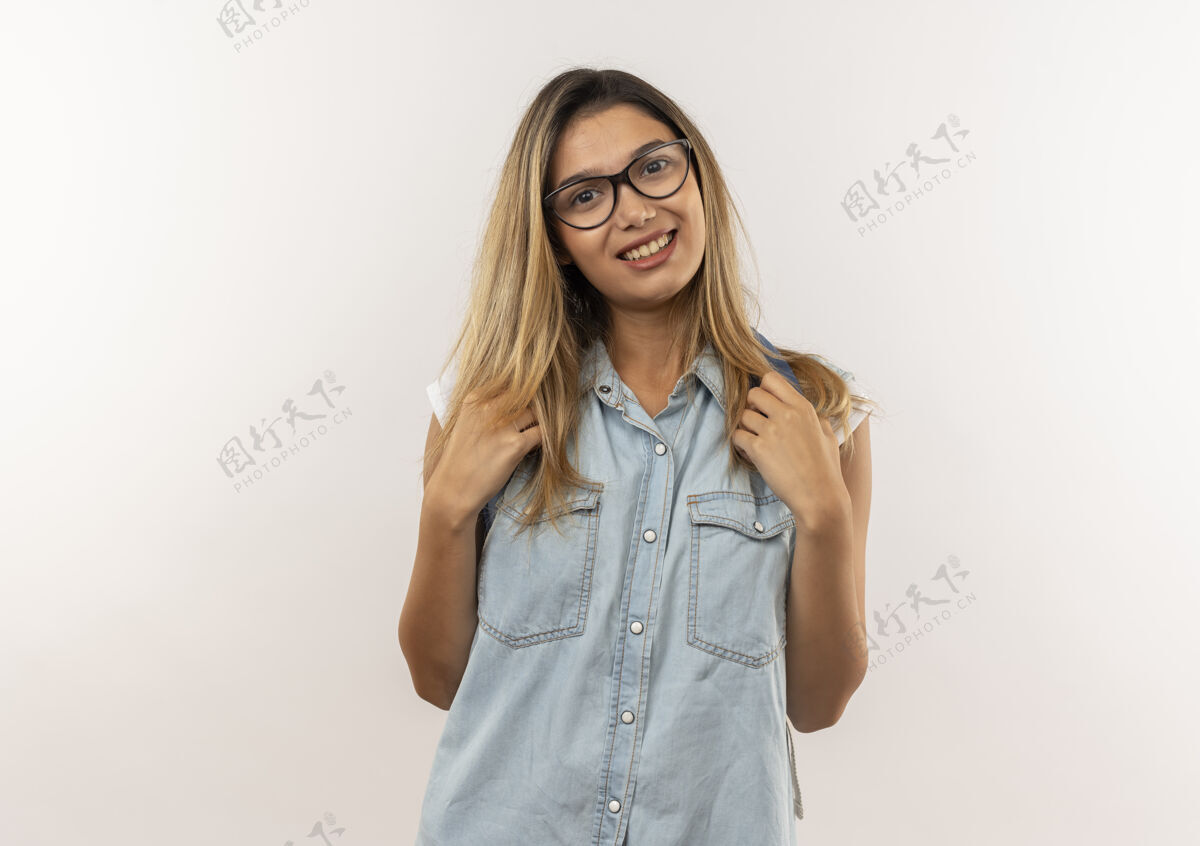 人微笑着的年轻漂亮的女学生戴着眼镜 背着背袋 背着背袋的背带隔离在白色的墙上年轻背部白色