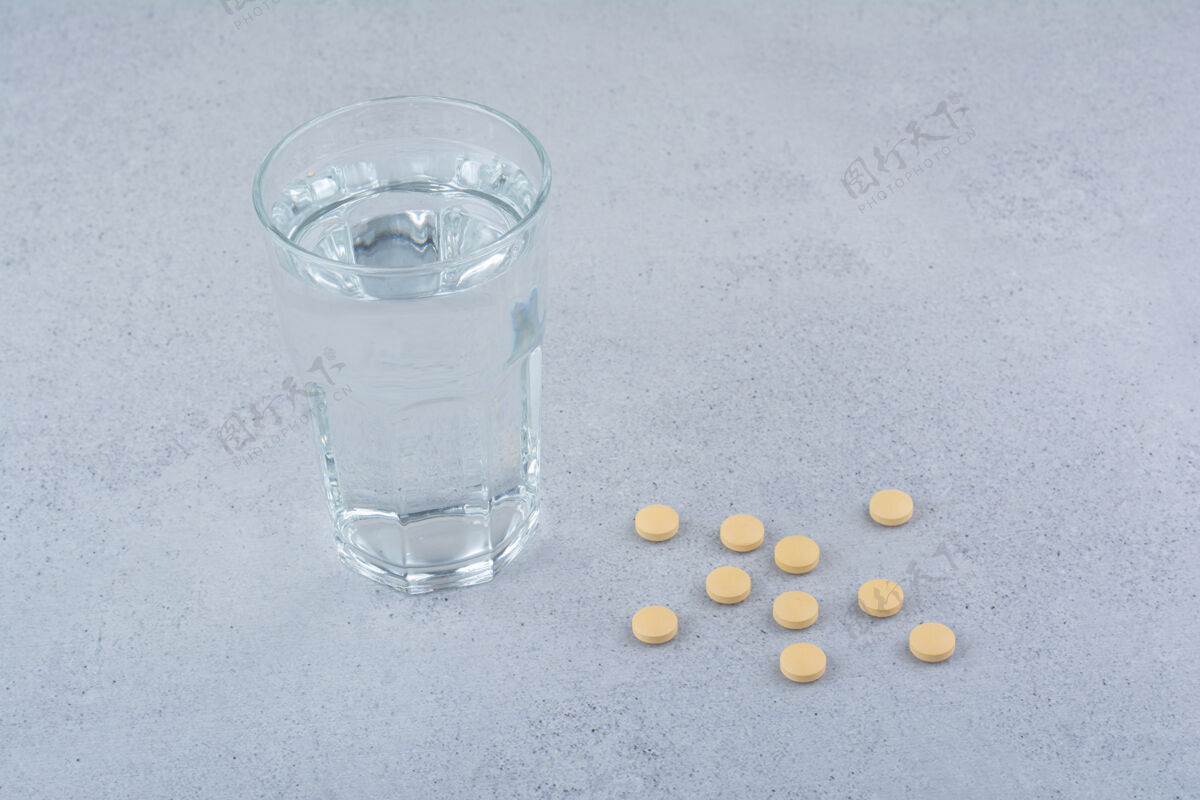 药品两包红色药丸和一杯水医疗药片药物
