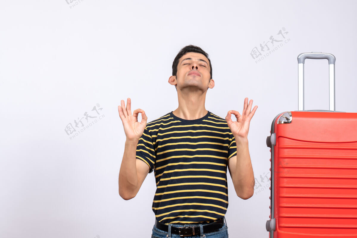 条纹正面图：一个穿着条纹t恤和红色手提箱的年轻人正在做一个“ok”的手势 闭上眼睛红色正面T恤
