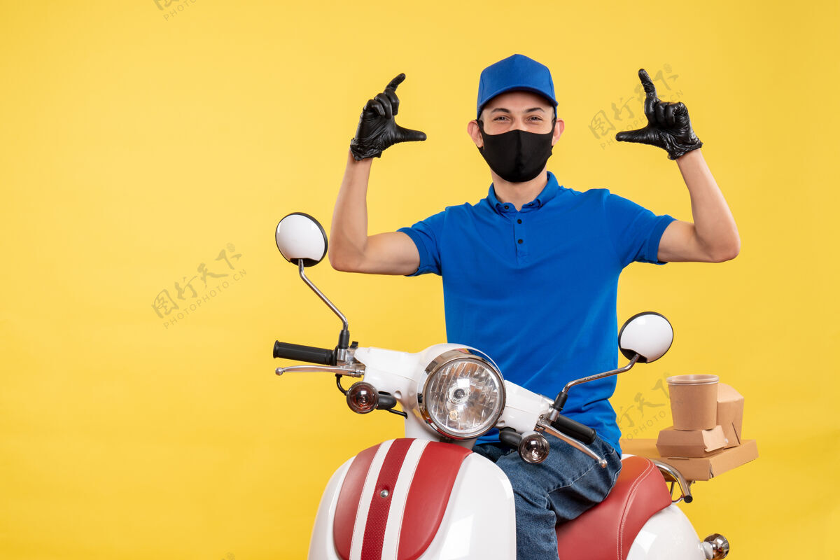 男人正面图黄色背景上穿着蓝色制服的年轻男性快递员职业大流行快递服务病毒自行车工作流行病蓝色制服