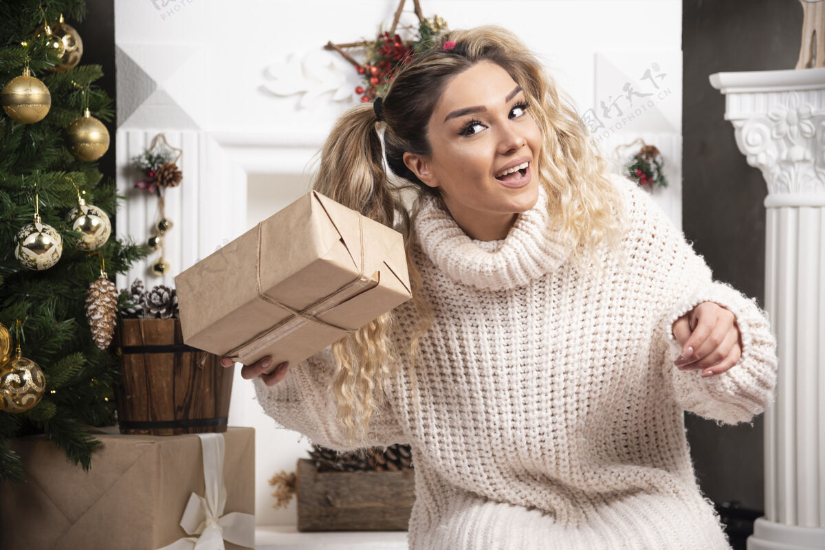 礼物一个穿着白色毛衣的年轻女子展示着两盒圣诞礼物女人盒子人