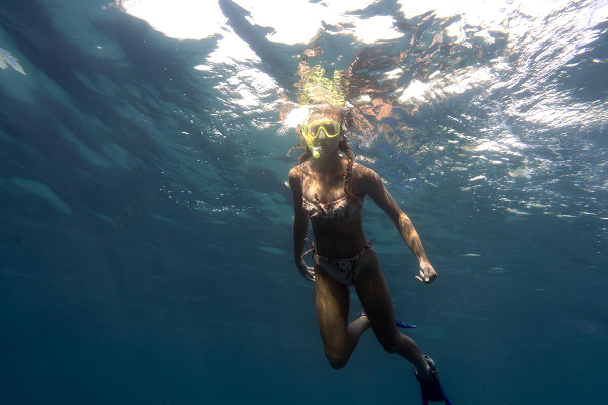 水戴着潜水器在海里游泳的女人水上游泳游泳