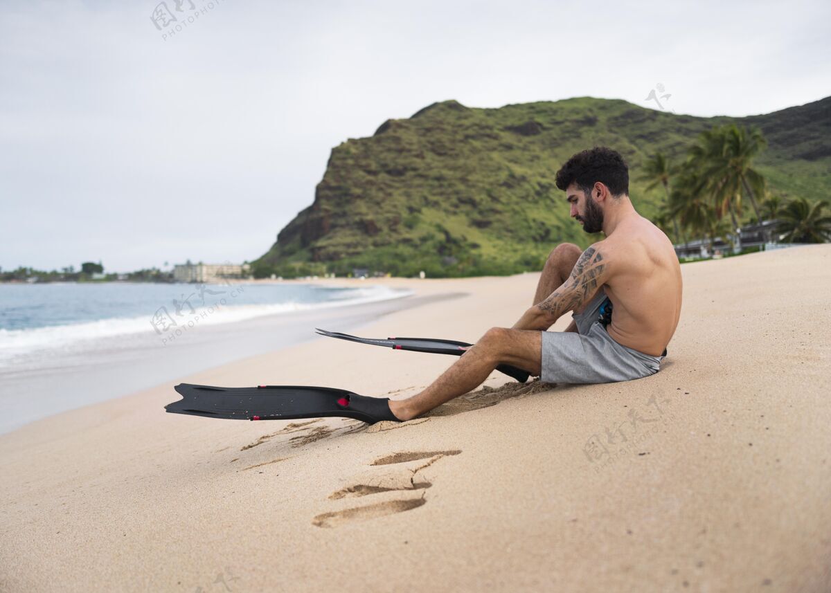 男性年轻的赤膊男子在沙滩上用潜水设备成人海滩人