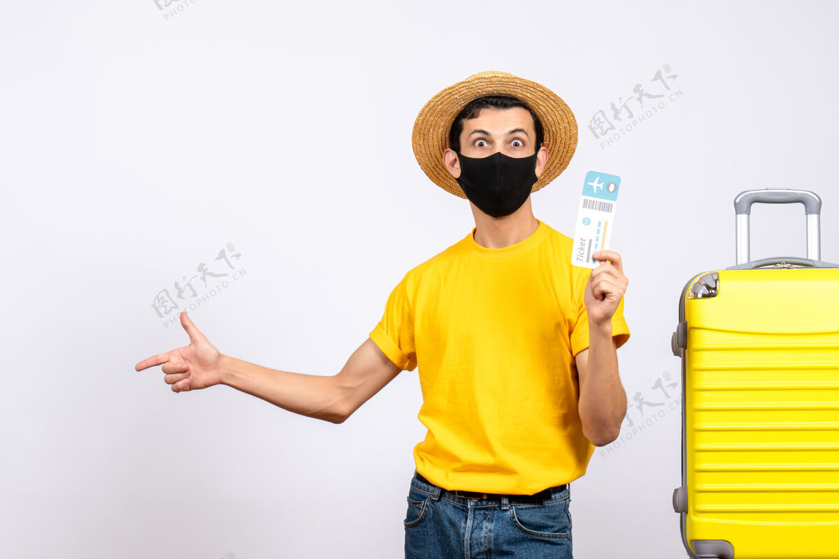 手提箱正面图穿着黄色t恤的年轻人站在黄色手提箱旁 手里拿着旅行票视图黄色向上
