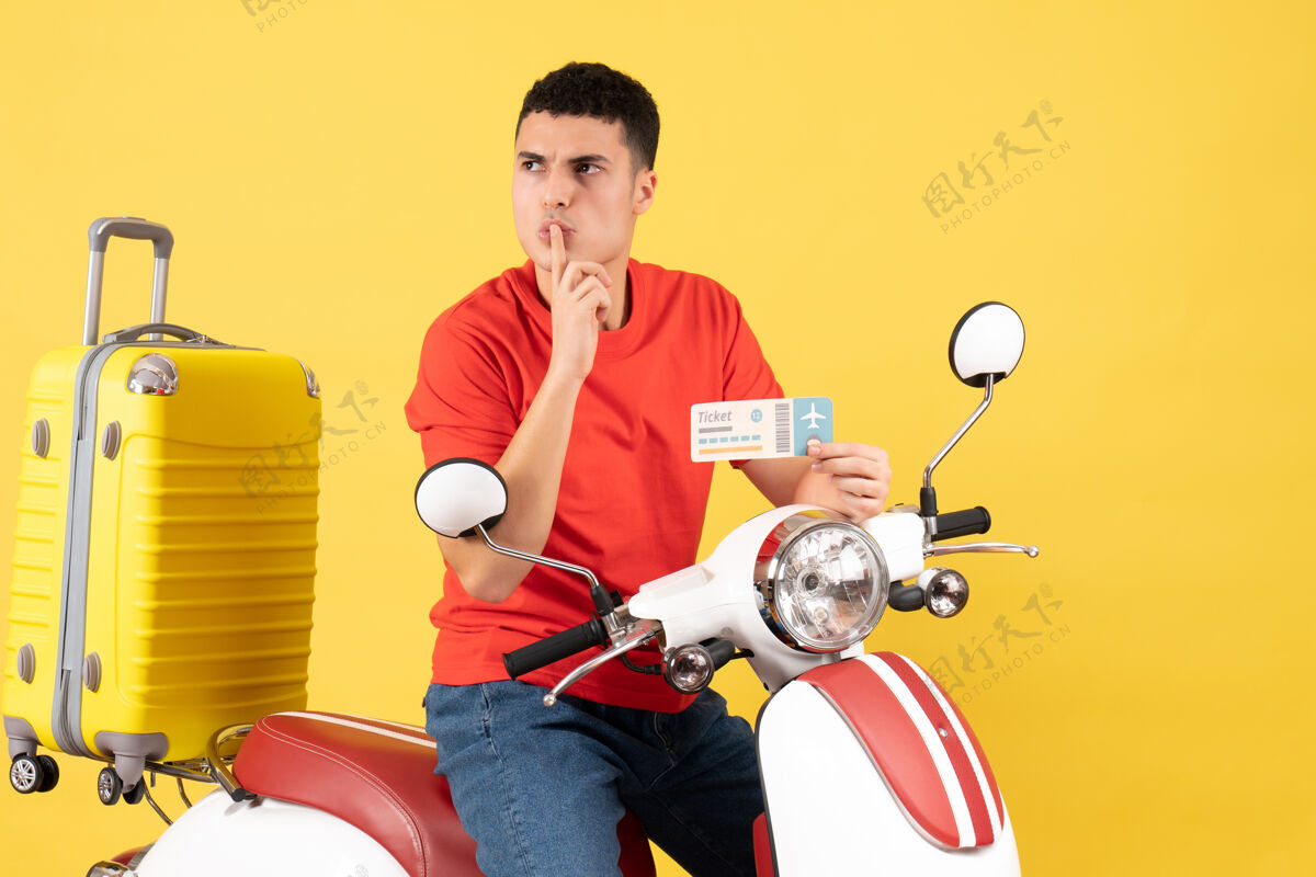 安静前视图：坐在轻便摩托车上的年轻人拿着售票牌嘘年轻人抱着男