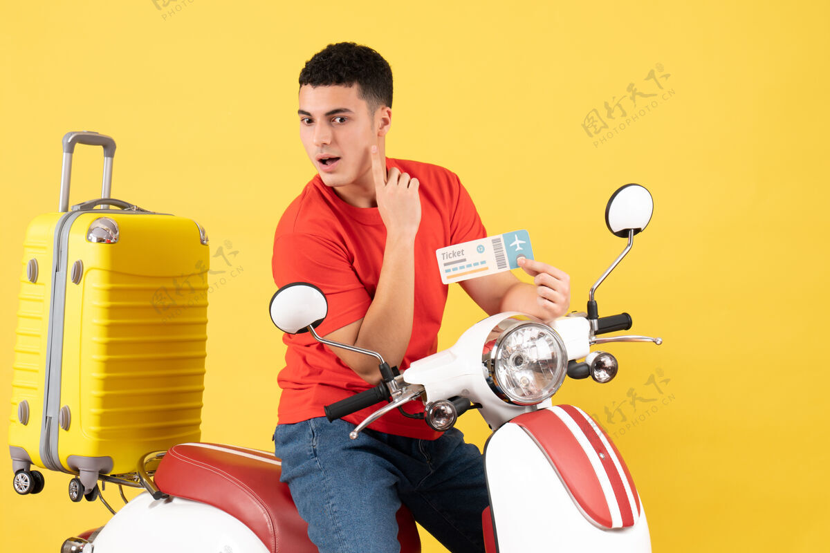 人前视图骑着轻便摩托车的年轻人拿着车票在想什么微笑票轻便摩托车